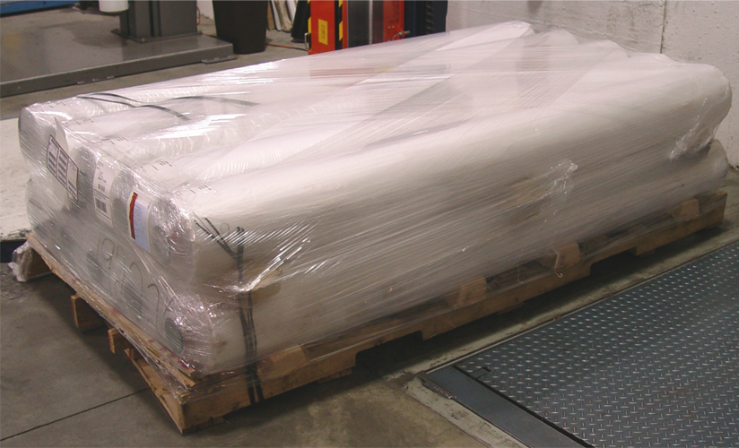 eight large rolls of polyethylene plastic sheeting wrapped in pe stretch wrap on pallet in loading bay