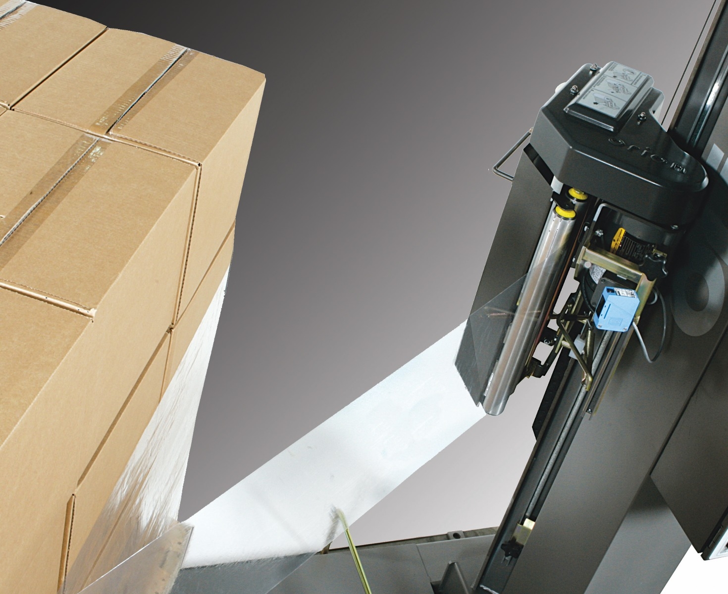 automatic stretch wrapper wrapping film around palletized stack of corrugated boxes