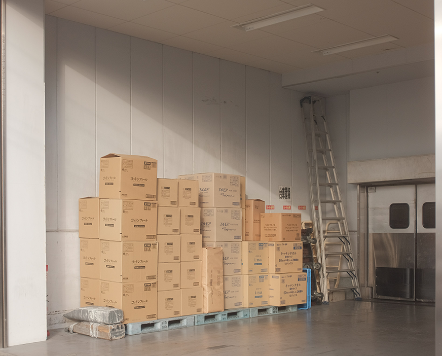 corrugated boxes stacked on pallets in outdoor storage area